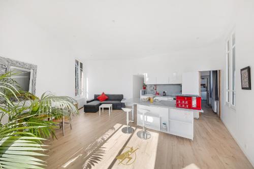 Il comprend une cuisine blanche et un salon avec un canapé. dans l'établissement Spacieux et lumineux - Coeur de quartier Gare de Hyeres - Wifi Fibre, à Hyères