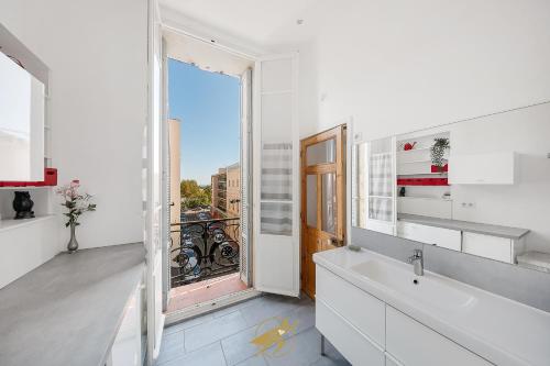 une salle de bain avec un lavabo et une grande fenêtre dans l'établissement Spacieux et lumineux - Coeur de quartier Gare de Hyeres - Wifi Fibre, à Hyères
