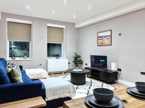 a living room with a blue couch and a tv at Sunny Central 3BR Brighton Retreat in Brighton & Hove
