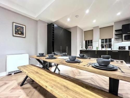 a kitchen with a long wooden table with bowls on it at Sunny Central 3BR Brighton Retreat in Brighton & Hove