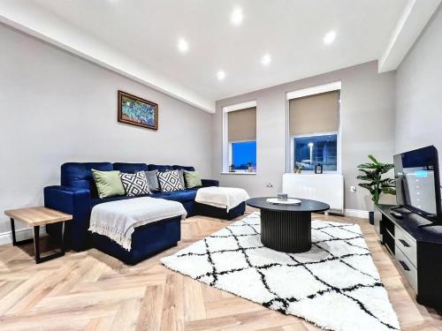 a living room with a blue couch and a tv at Sunny Central 3BR Brighton Retreat in Brighton & Hove