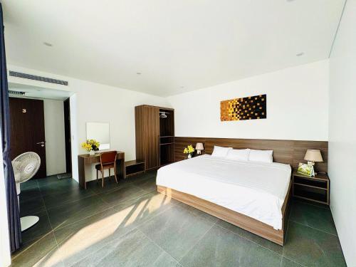 a bedroom with a white bed and a desk with a chair at Villa 4PN Dream in Dong Hoi