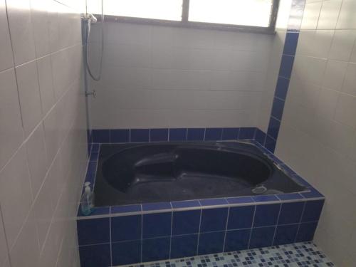 a bath tub in a bathroom with blue tiles at Villa Juan jose in Anapoima