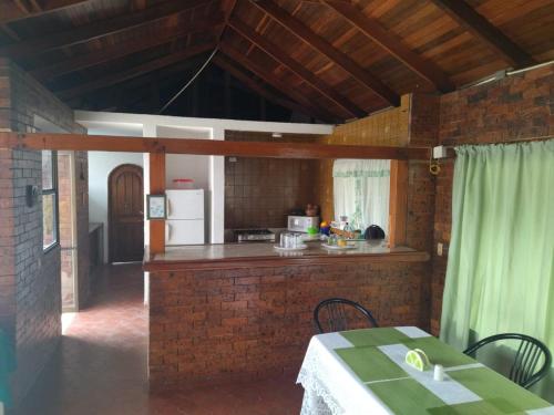 a kitchen with a table and a brick wall at Villa Juan jose in Anapoima