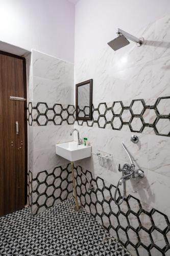 a bathroom with a sink and black and white tiles at Relax Inn Jaisalmer in Jaisalmer