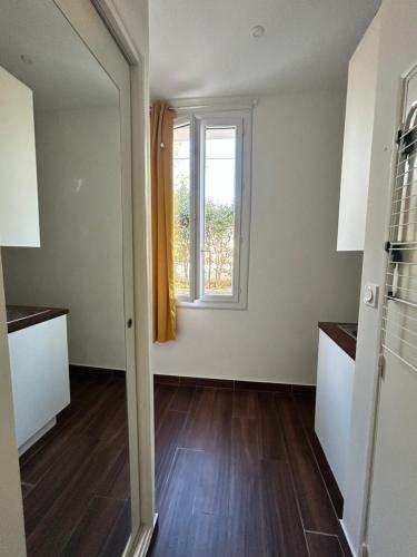 Cette chambre vide dispose d'une fenêtre et de parquet. dans l'établissement Agréable Studio Rénové avec place de parking, à Bandol