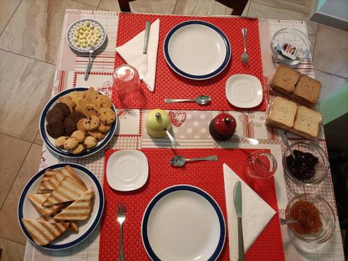 a table with plates of food on a red table cloth at Le Colline di Maggiora B&B in Maggiora