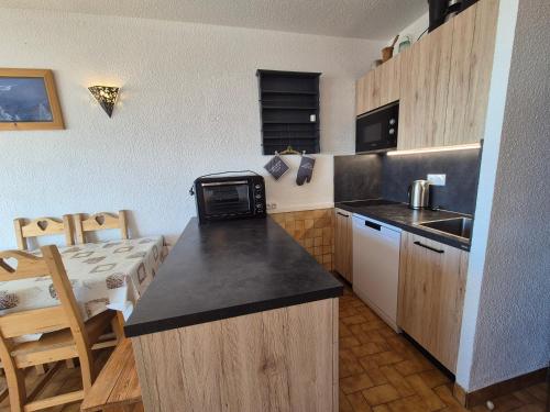 une petite cuisine avec un comptoir et un four micro-ondes dans l'établissement Chalet de la Rosière 8E - Appartement 5 pers, pied des pistes - La Rosière, à Montvalezan