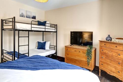 a bedroom with two bunk beds and a dresser at Front RIVER private BEACH 2 HOT TUBS 15 p SAUNA in Labelle