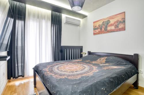 a bedroom with a bed with a black comforter at Luxury Apartment Veselić in Valjevo