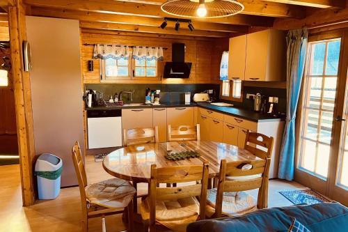 a kitchen and dining room with a table and chairs at BEAUTIFUL CHALET in nature near Gerardmer! in Rochesson