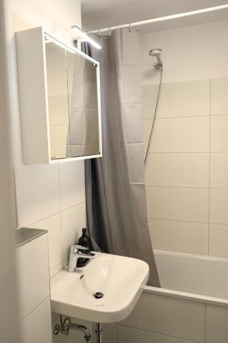 a white bathroom with a sink and a shower at Robins - spacious for 5 - balcony - kitchen - WiFi in Bremen