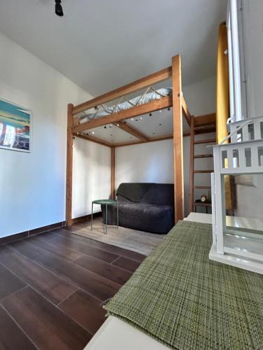 un salon avec un lit mezzanine et un canapé dans l'établissement Agréable Studio Rénové avec place de parking, à Bandol