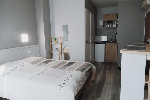 une chambre avec un lit et une cuisine dans l'établissement Appart hôtel Bourges, à Bourges