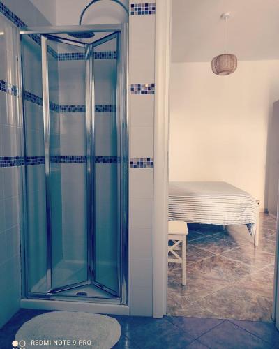 a glass shower in a room with a bed at B&B Casa Dolce Casa Monopoli in Monopoli