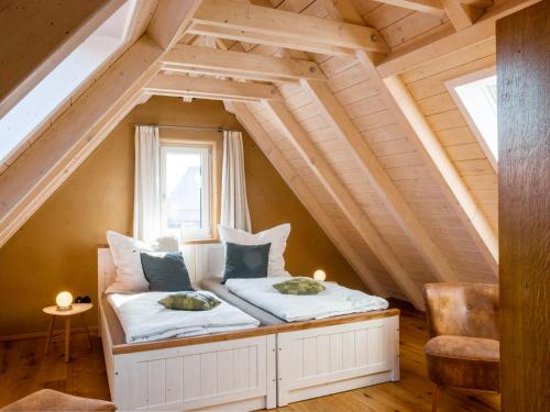 a bed in the attic of a house at Ferienhaus Herrmanns Häuser - Leipziger Neuseenland - großzügiges Ferienhaus - WLAN - Parkplatz - TOP in Rötha