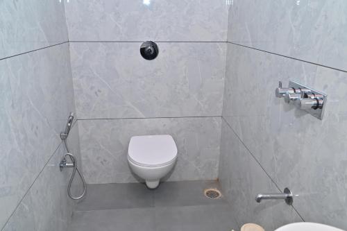 a bathroom with a white toilet and a shower at Hotel Sai Sneha in Shirdi