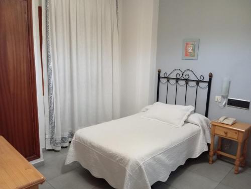 グアダルーペにあるHOSTAl LUJUANのベッドとテーブルのある小さな寝室