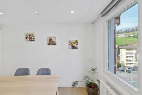 a dining room with a table and chairs and a window at book2stay - Apartments Herisau in Herisau