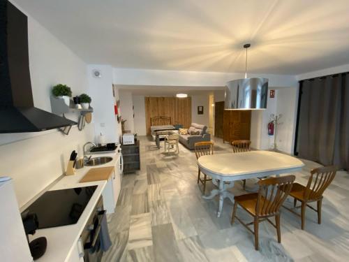 a kitchen and living room with a table and chairs at Apartamentos el Sótano in Badajoz