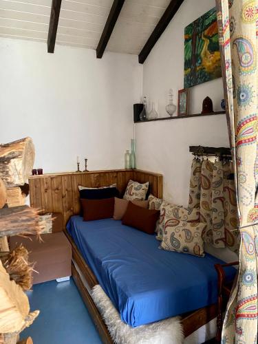 a bedroom with a bed with blue sheets and pillows at Cottage Vivenda Festina Lente in Figueiró dos Vinhos