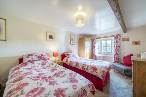 una camera da letto con due letti e un divano di Drawell Cottage - Situated on a working farm a Sedbergh