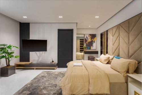 a bedroom with a large bed and a flat screen tv at Modern Havens in Lekki