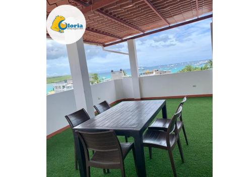 a table and chairs on a balcony with a view of the ocean at Gloria - Galápagos Inn in Puerto Ayora