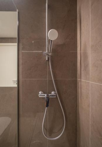 a shower with a shower head in a bathroom at Waves Nazare - by Smarthomes in Nazaré