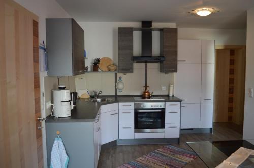 a kitchen with white cabinets and a stove top oven at Häringer Mühle in Bad Häring