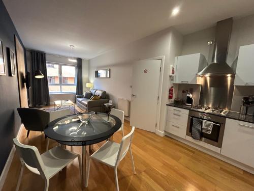 a kitchen and living room with a table and chairs at Principal Apartments - Merchant City in Glasgow
