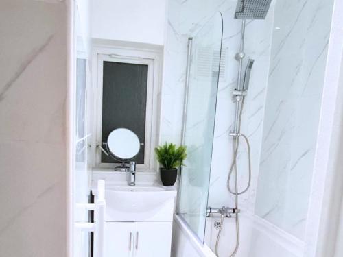 ein Badezimmer mit Waschbecken und Spiegel in der Unterkunft Modern Penge East Apartment in Sydenham