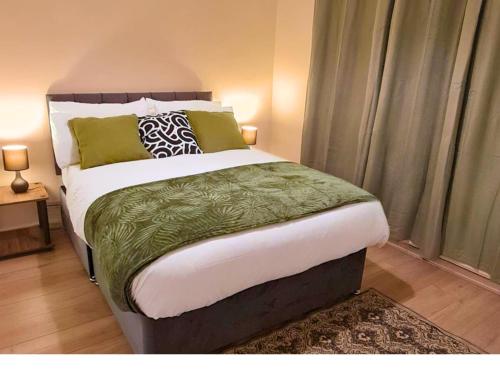 Schlafzimmer mit einem großen Bett in Grün und Weiß in der Unterkunft Modern Penge East Apartment in Sydenham