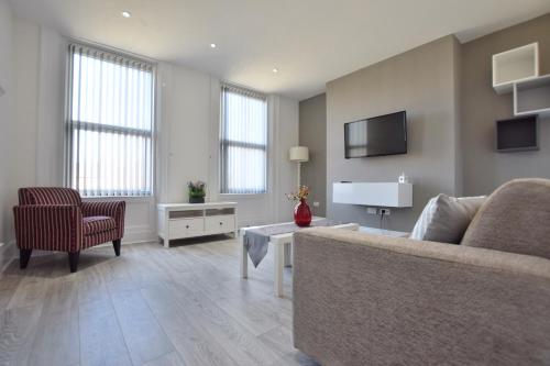 a living room with a couch and a tv at Dwell Living Mowbray in Sunderland