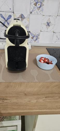 a slow cooker on a table with a bowl of tomatoes at Garibaldi Apartment Sanremo in Sanremo
