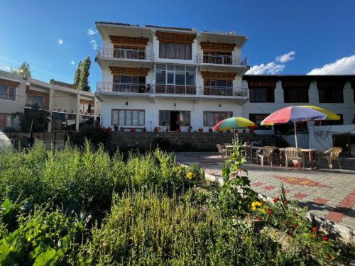 a building with two umbrellas in front of it at yangphel house in Leh