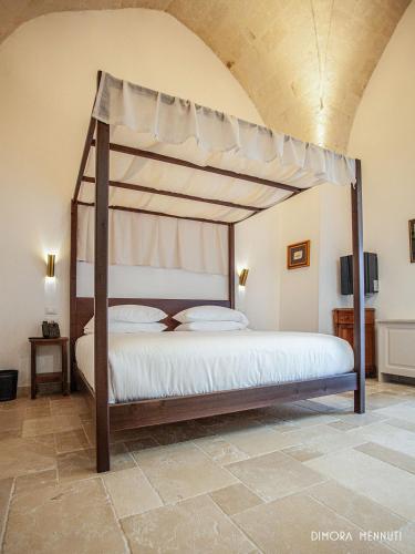 a bedroom with a canopy bed in a room at Dimora Mennuti in Monteparano