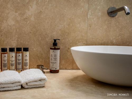 a bathroom counter with a sink and a white bowl at Dimora Mennuti in Monteparano