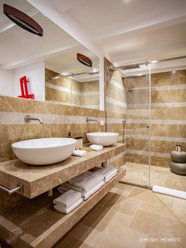 a bathroom with two sinks and a shower at Dimora Mennuti in Monteparano