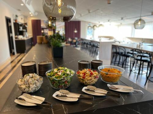a table with bowls of food on top of it at Injoy Premium Hotel Solna in Solna