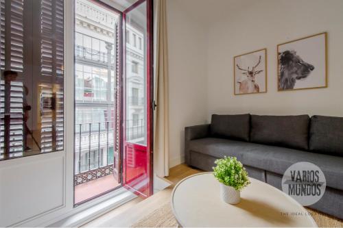 a living room with a couch and a table at Tu balcón en Madrid para 3, Carretas 25 in Madrid