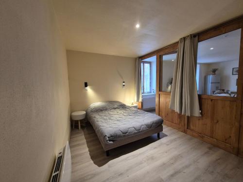 une chambre avec un lit dans une pièce avec une fenêtre dans l'établissement T2 BOURGEAT - Charmant 2 pièces - Centre ville, à Bourg-Saint-Maurice