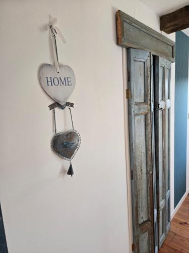 a heart hanging on a wall with a home sign at Gites Souleilla de la Nine in Canens