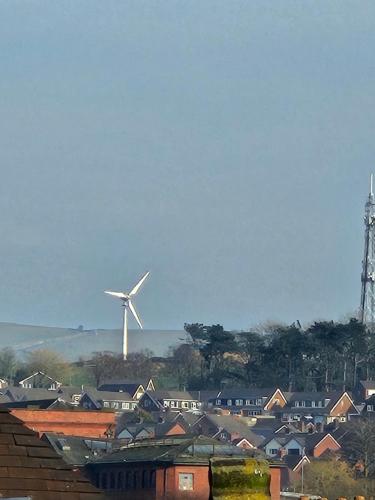 a city with a windmill in the background with houses at Central Chambers Suites - Suite 4 in Leek