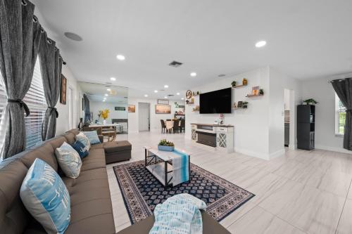 a living room with a couch and a tv at Sweet Pink HouseCozy & QuietNear Beach, Parks in Riviera Beach