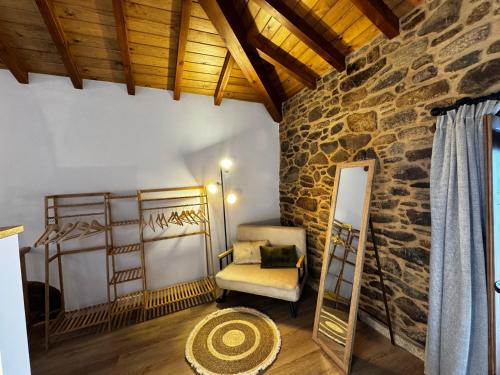 a room with a chair and a stone wall at Casa Erundina in Camariñas
