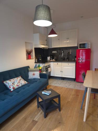 un salon avec un canapé bleu et une cuisine dans l'établissement Paris Stade de France, à Saint-Denis