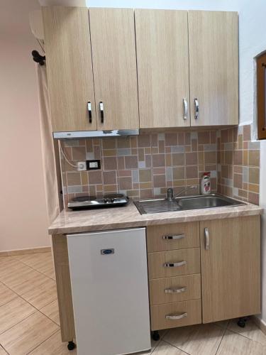 a kitchen with wooden cabinets and a sink at House Pollo in Ksamil