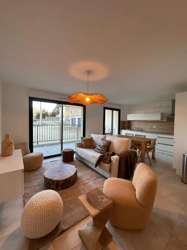 un salon avec un canapé, des chaises et une table dans l'établissement Appartement neuf 6 personnes JARDIN, à Formiguères