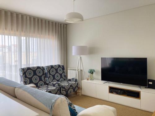 a living room with a couch and a television at nearsea in Lavra